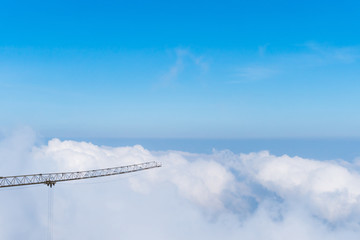 Fototapeta na wymiar A crane is a type of machine above beautiful white cloud summer blue sky and sun light.