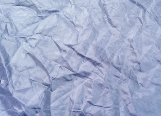 Dark blue crumpled textile, close up view. Dark blue fabric, an abstract background. Crumpled sheet texture. Background for banners, or wallpapers