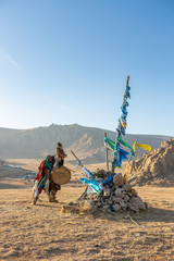 mongolia shaman performed spiritual around Ovoo or Shaman's Shrine at the top of moutain and warm sunset