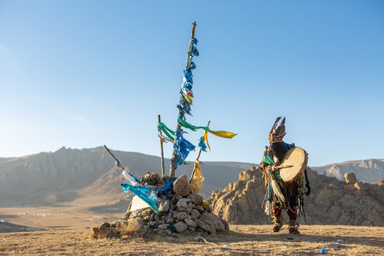 mongolia shaman performed spiritual around Ovoo or Shaman's Shrine at the top of moutain and warm sunset