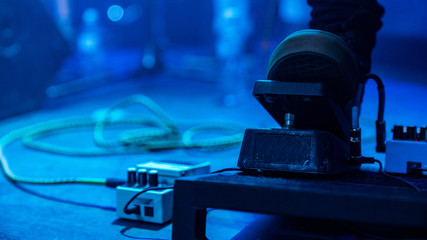 The crowd at the concert. Summer music festival. Silhouettes of the leg of a concert performer on the stage in front of the cheering crowd in colorful bright stage lights.