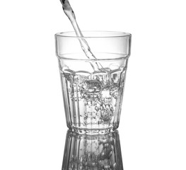 Pouring clean drinking water on a transparent glass. For health concepts. Isolated white background