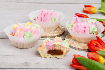 Flowers tulips dessert cake shot on white wooden background
