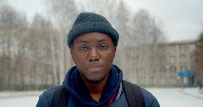 lonely black man seriously looking at camera close up confident portrait american face 4K. Angry black face guy with tense sight from cold. Successful portrait african people with serious look.
