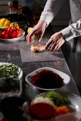 Chief chops and marinates chicken. Professional chef in a kitchen of restaurant cooking.