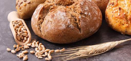 Wholegrain rolls or bread for breakfast and seeds with ears of rye or wheat grain