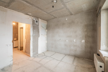 Empty interior for design, gray concrete wall. Empty room. Space for text and picture. Concrete walls, slabs, interior of a new residential building. Partitions in a new apartment.