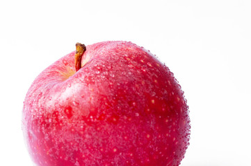 One red apple with water droplets on the skin on a white background
