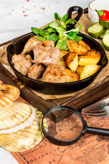 Potato with meat in a pan and fresh vegetables