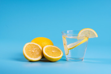 Lemonade with fresh lemons on blue background