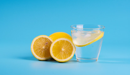 Lemonade with fresh lemons on blue background.  Selective focus. Copyspace concept.