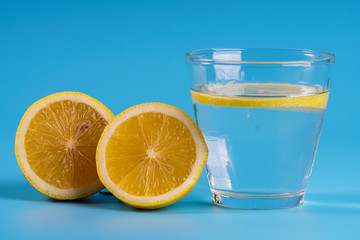 Lemonade with fresh lemons on blue background