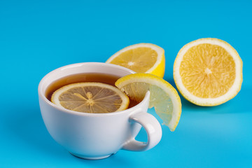 A cup of a lemon tea overblue background.