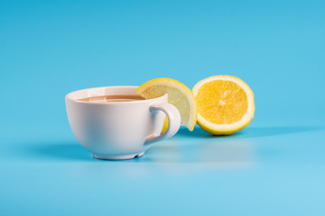 Obraz na płótnie Canvas A cup of a lemon tea overblue background.