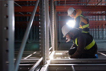 Maintenance technician service in cold warehouse storage, Machinery engineering people checking...