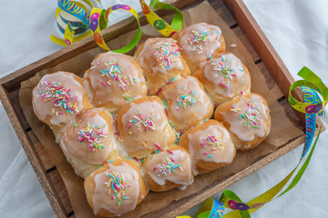 Fototapeta na wymiar sweet home made Carnival powdered sugar raised donuts with paper streamers