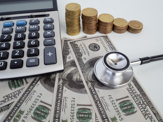 Fototapeta premium Stethoscope over pile of dollar and calculator. Savings, bank..Financial analysis concept.