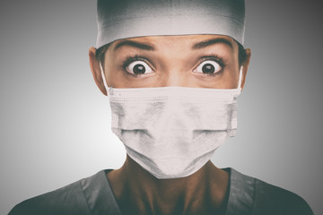 Virus scare Asian doctor woman shocked wearing coronavirus mask protection looking scared. China hospital staff.