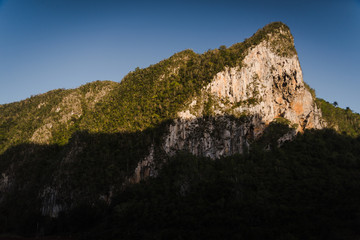 A rock face on a mountian lit up by the sunset. 