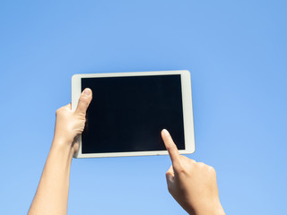 finger touching screen with blue backgroun, isolated on blue sky