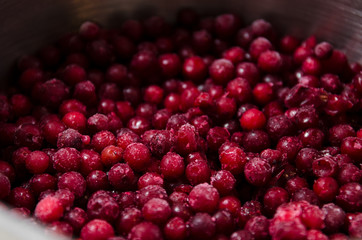Frozen lingonberries in a saucepan for cooking compote.