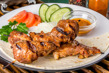 Pork neck steak with fresh vegetables on a white plate
