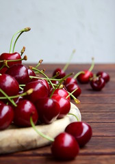Leckere rote frisch geerntete Kirschen auf einem Holztisch - Sommerzeit ist Kirschenzeit
