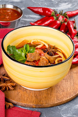 Lagman with meat and broth in a yellow plate