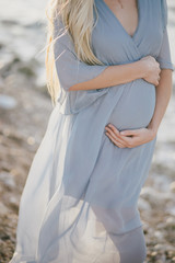 Pregnant woman belly close up outdoors.