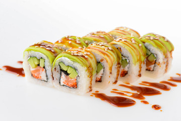 Uramaki tori sushi, a set of green rolls with sesame seeds and unagi sauce isolated on white. Eight pieces of sushi.