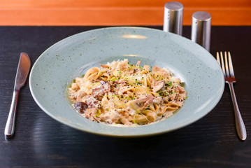 Traditional Italian pasta with cherry tomato, parmezan cheese and parsley served on white plate