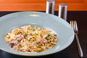 Traditional Italian pasta with cherry tomato, parmezan cheese and parsley served on white plate