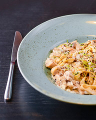 Traditional Italian pasta with cherry tomato, parmezan cheese and parsley served on white plate