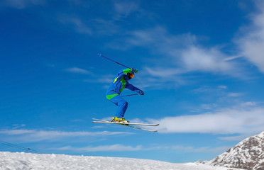 Naklejka na ściany i meble Male skier jumps in snow park against the blue sky. Livigno, Italy