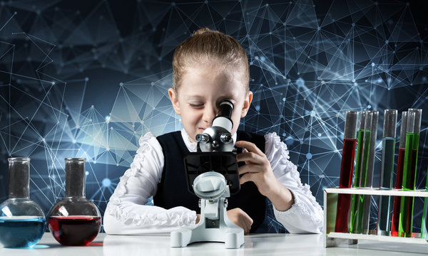 Little scientist looking through microscope