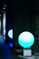 Multicolored round lamps are on the street along the building as a decoration