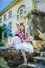 Girl in a white dress with a pink rifle plays airsoft