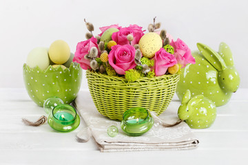 Easter table decoration with roses, moss and catkins.