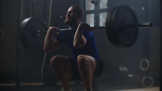 Young sportsman lifting heavy barbell. Healthy, muscular. Strong man doing barbell snatch exercise at the gym in slow motion. Sportsman on exercise mat doing situps in gym. 
