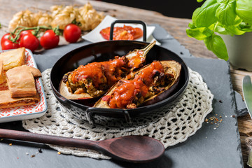 Baked melanzani filled with cheese and vegetables served in a rustic pan