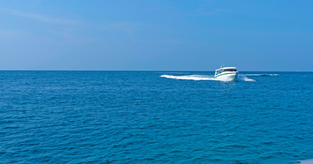 - White ship sails on blue sea, on waves in tropics, summer