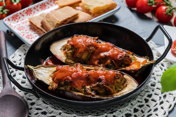 Baked melanzani filled with cheese and vegetables served in a rustic pan