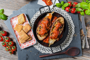 Baked melanzani filled with cheese and vegetables served in a rustic pan