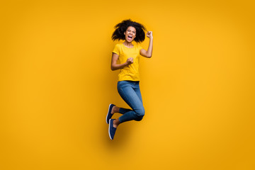 Fototapeta na wymiar Full length body size view of her she nice attractive lovely cheerful cheery overjoyed crazy wavy-haired girl jumping celebrating isolated on bright vivid shine vibrant yellow color background