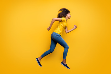 Fototapeta na wymiar Full length body size profile side view of her she nice attractive lovely cheerful cheery wavy-haired girl running active life isolated on bright vivid shine vibrant yellow color background
