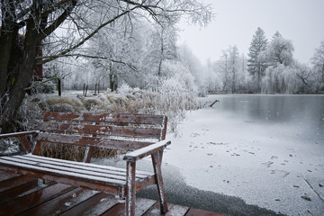 Winter seeting. Pier and bench on frozen lake. Winter landscape 