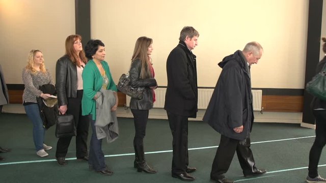 People Queue or Waiting in line. Indoors. Queueing up. View from the side