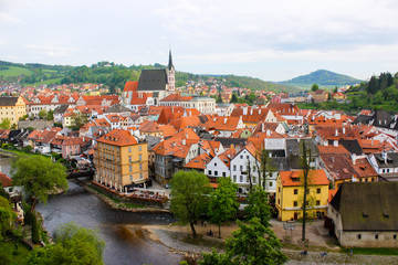 Fototapeta na wymiar Aerial panoramic view of the typical colorful houses of Cesky Krumlov with Vltava river at the foreground and St. Vitus Church at the background (Czech Republic)