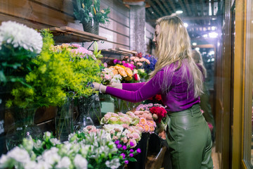  young woman florist standing and working in flower shop