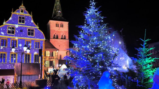 Gran abeto azul de navidad decorado con luces y fondo de fachada de iglesia por la noche
